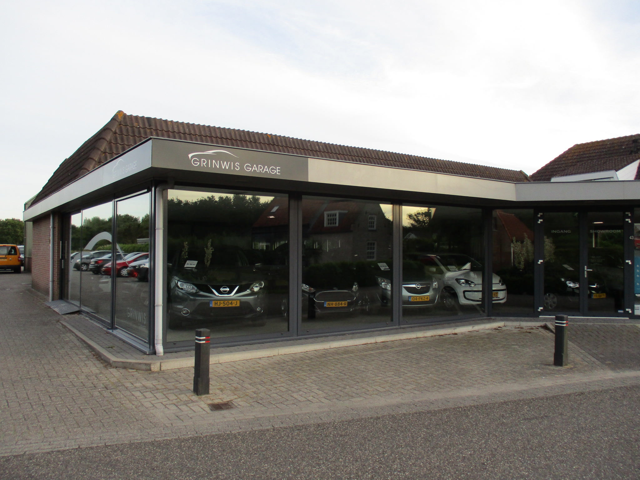 De showroom van Garage Grinwis aan de Dorpsweg in Ouddorp met auto's achter het glas
