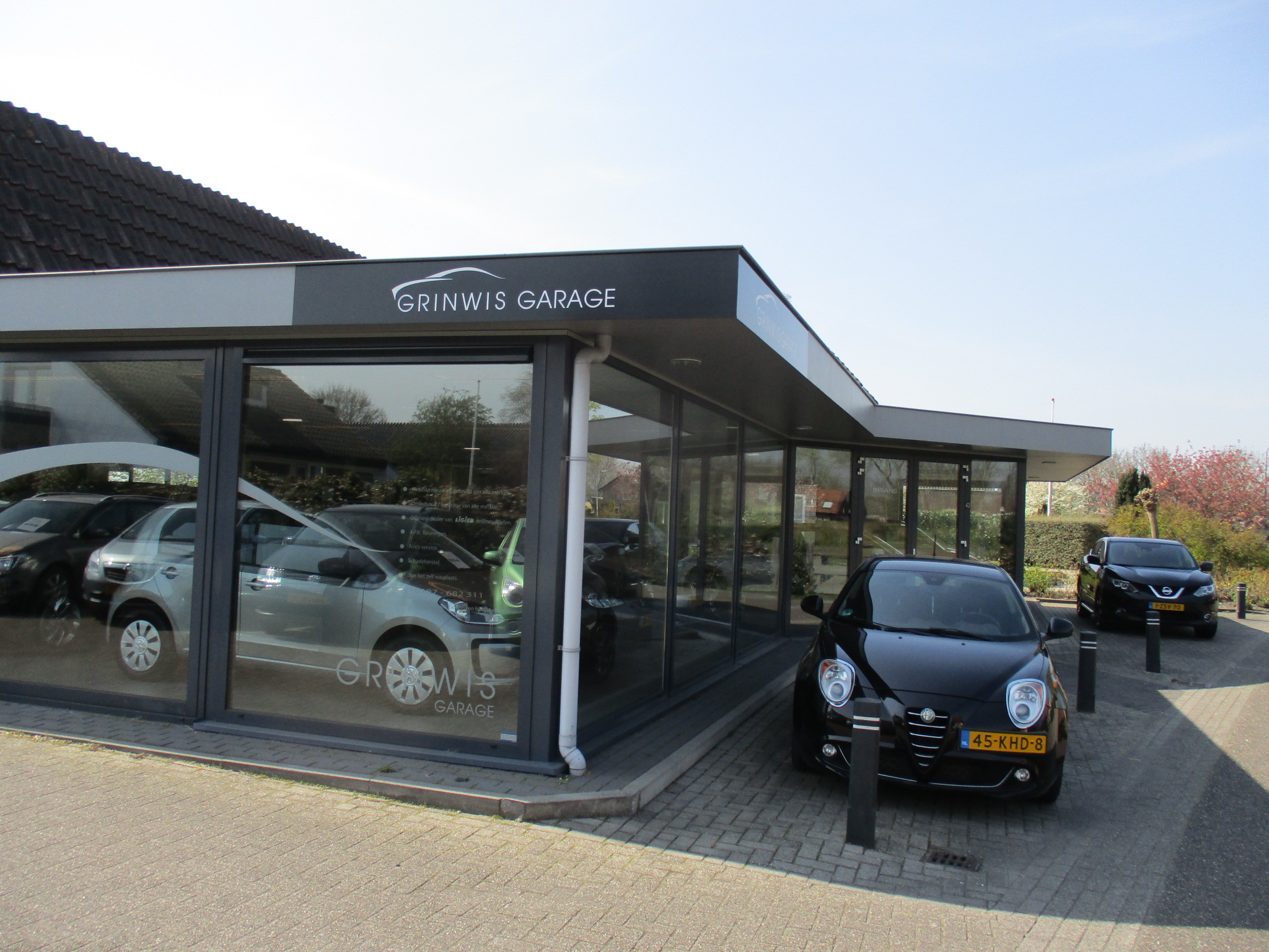 Garage Grinwis aan de Dorpsweg in Ouddorp: de glazen showroom met het bord Grinwis Garage op de gevel