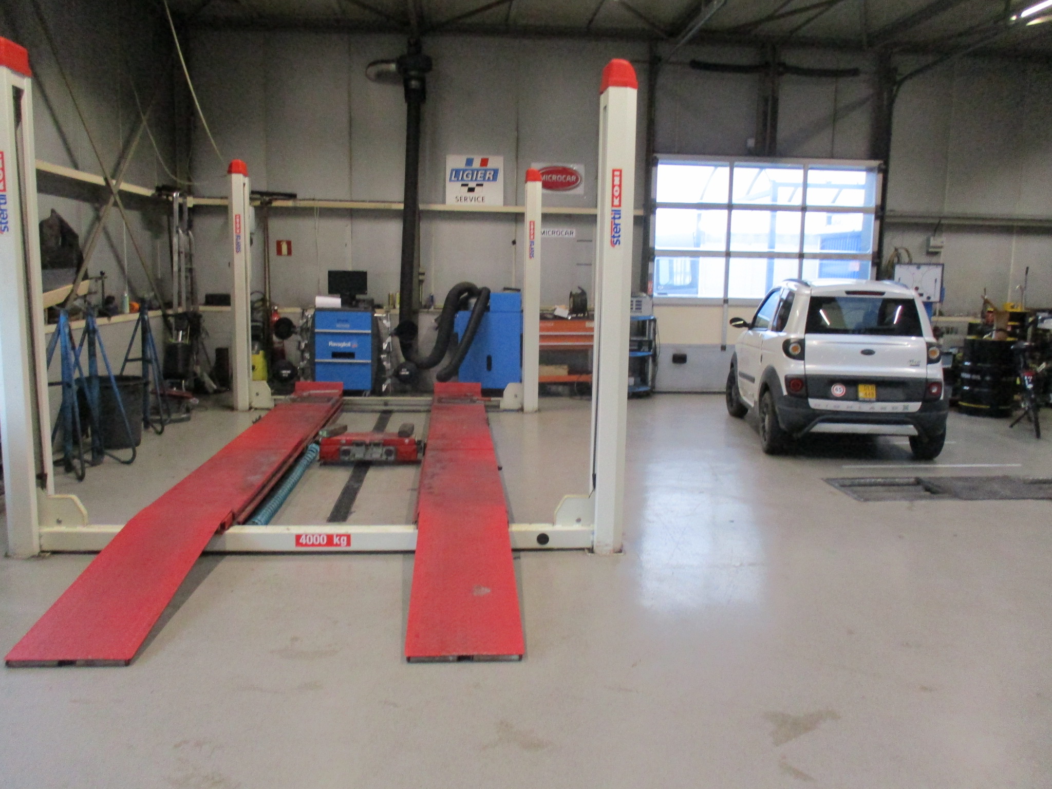 De uitlijnbrug met rode opritten in de werkplaats van Garage Grinwis